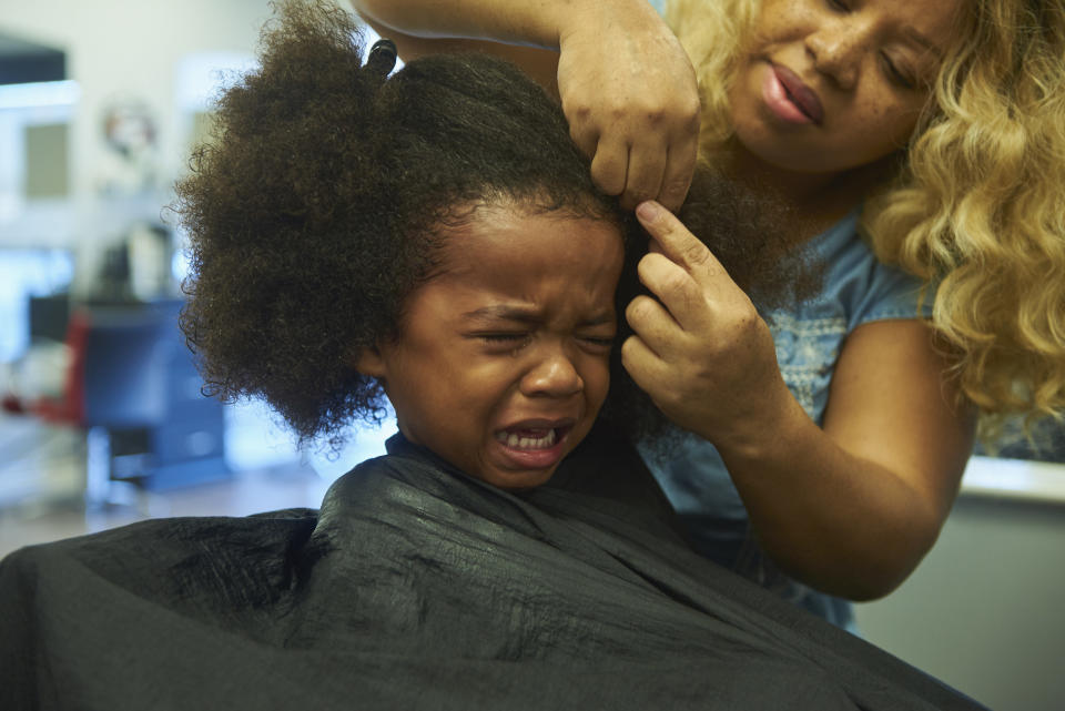 A child crying during their haircut