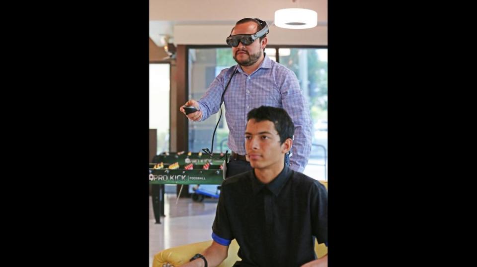 Director of creative technology at the Dan Marino Foundation, Santiago Bolivar, demonstrates how to use the Magic Leap virtual reality headset to Kyle Engelmann, 19, at the Dan Marino Foundation Marino Campus in Fort Lauderdale. The headset provides a virtual interview with a human-like avatar for those on the autism spectrum, thus eliminating the face-to-face interview.
