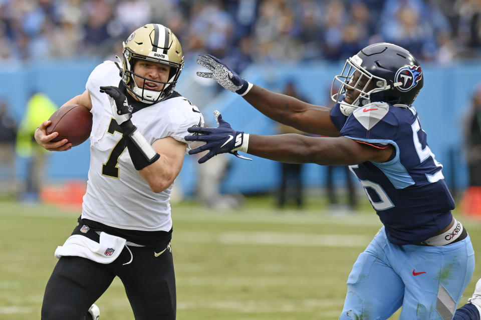 New Orleans Saints quarterback Taysom Hill (7) scrambles away from Tennessee Titans linebacker Monty Rice (56) in the first half of an NFL football game Sunday, Nov. 14, 2021, in Nashville, Tenn. (AP Photo/Mark Zaleski)