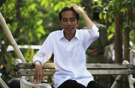 Indonesian presidential candidate Joko "Jokowi" Widodo sits on a bench while waiting for the announcement of the results from the Elections Commission at Waduk Pluit in Jakarta July 22, 2014. REUTERS/Beawiharta