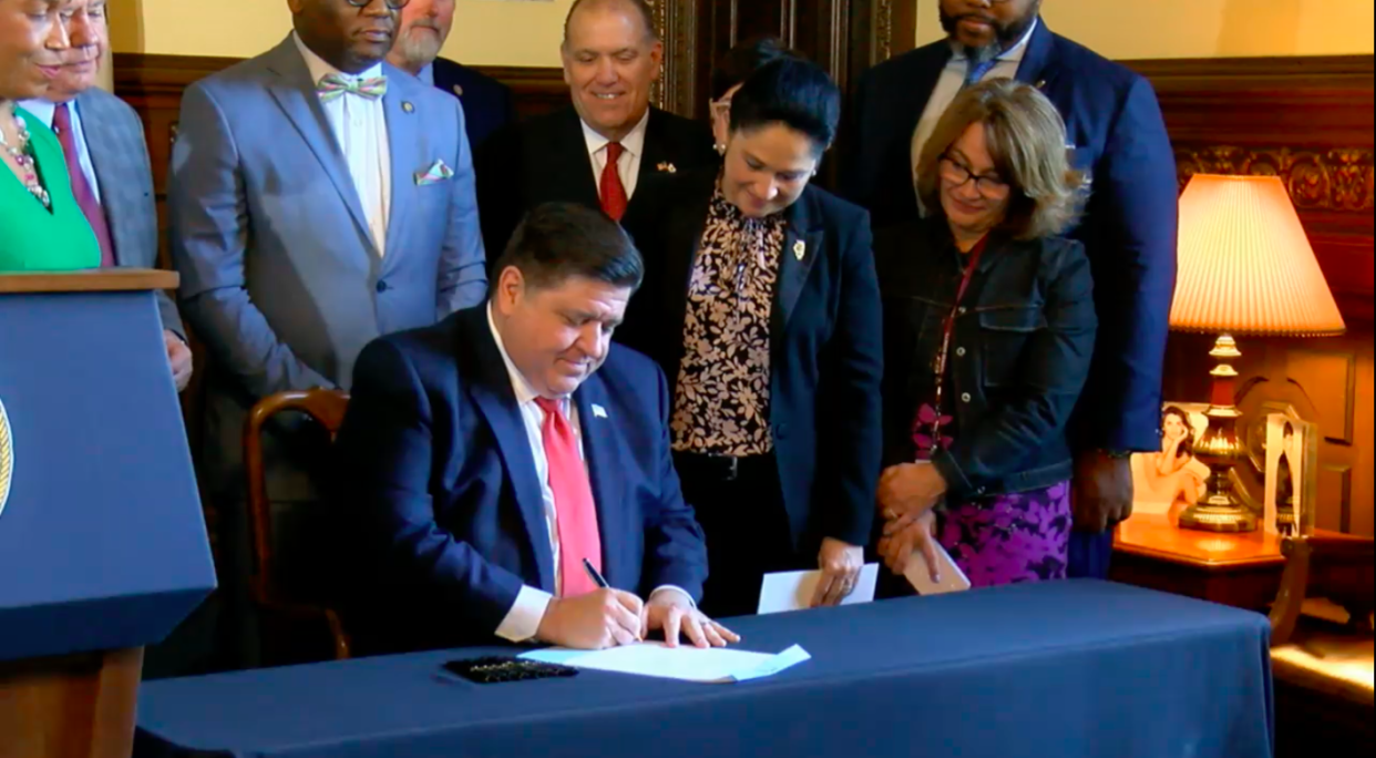 Gov. JB Pritzker, flanked by lawmakers and Comptroller Susana Mendoza, signed House Bill 3162 into law on Wednesday, May 10, 2023.