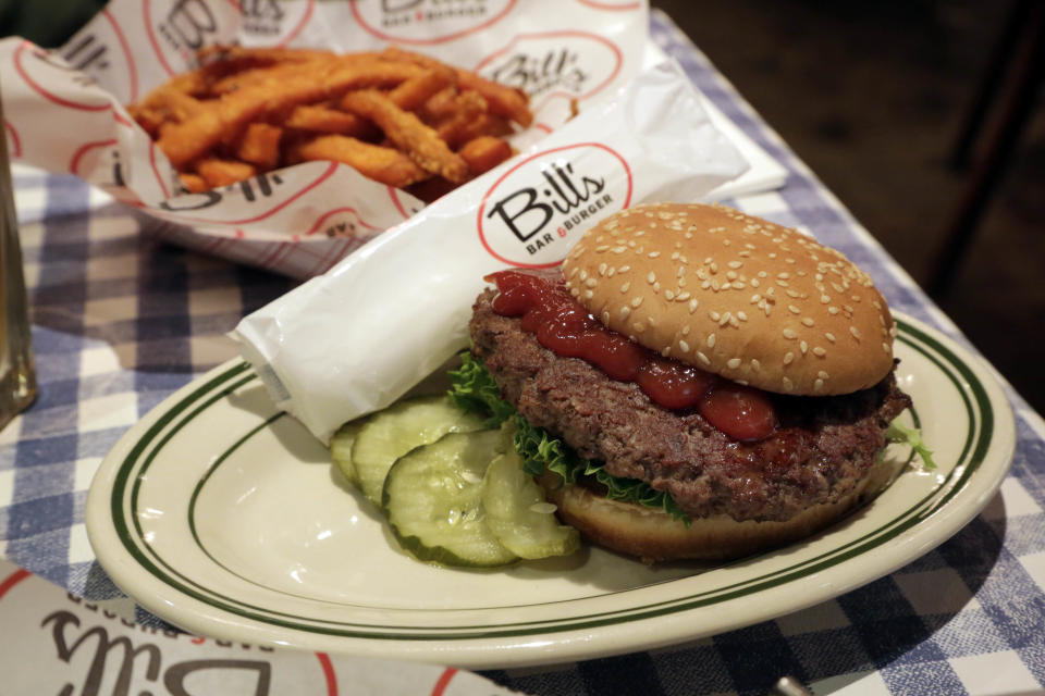 This Dec. 5, 2013 photo shows the Classic burger, on a toasted sesame bun, and sweet potato fries, at Bills Bar & Burger, in New York's Rockefeller Center. Rockefeller Center is crowded at Christmastime thanks to the famous tree, the skating rink and the show at Radio City Music Hall, but visitors can choose from a variety of places to eat in the area, from ethnic food and street carts to sit-down dining. (AP Photo/Richard Drew)