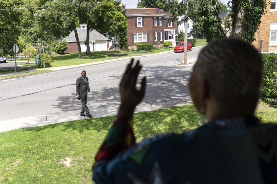 Trinity Baptist's Rev. Jimmie Hardaway Jr., rear, smiles as he's sung to by Marsha McWilson outside her home, Sunday, Aug. 20, 2023, in Niagara Falls, N.Y. In 2015, he was hired to replace the founding pastor at Trinity, about 2 miles (3 kilometers) from Niagara’s namesake falls. By then, he says, his worries about safety had faded, largely convincing him to leave his guns at home. Until one horrific night that June when a young man walked into a Bible study session at Emanuel African Methodist Episcopal Church in Charleston, S.C. and killed nine people. (AP Photo/David Goldman)