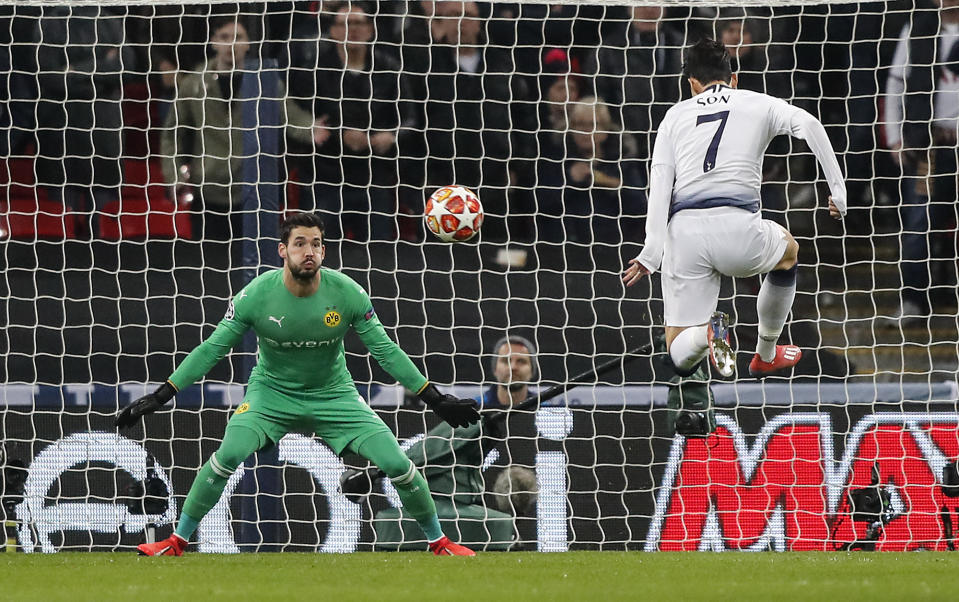 Tottenham midfielder Heung-Min Son, right, scores the opening goal against Dortmund goalkeeper Roman Buerki during the Champions League round of 16, first leg, soccer match between Tottenham Hotspur and Borussia Dortmund at Wembley stadium in London, England, Wednesday, Feb. 13, 2019. (AP Photo/Frank Augstein)