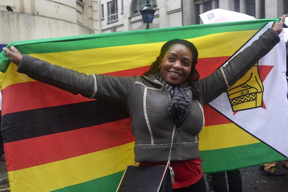 A woman holds a Zimbabwe flag on The Strand (AFP/Getty Images)
