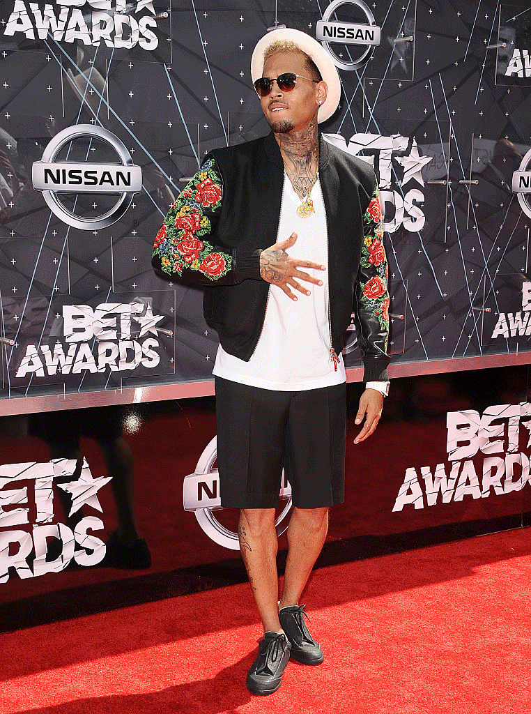 Chris Brown – Le chanteur s’offre un look décontract’ sur tapis rouge en alliant short, bomber et chapeau. Résultat : un ensemble simple et efficace !