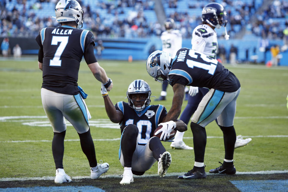 Carolina Panthers quarterback Kyle Allen (7) and wide receiver D.J. Moore (12) assist wide receiver Curtis Samuel (10) following Samuel's touchdown against the Seattle Seahawks during the second half of an NFL football game in Charlotte, N.C., Sunday, Dec. 15, 2019. (AP Photo/Brian Blanco)