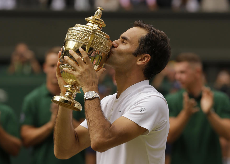 FILE - In this July 16, 2017, file photo, Switzerland's Roger Federer kisses the trophy after defeating Croatia's Marin Cilic to win the Men's Singles final match at the Wimbledon Tennis Championships in London. Federer's paths to his record eight Wimbledon championships were each different, of course. Different opponents. Different degrees of difficulty. Same old Federer. (AP Photo/Alastair Grant, File)