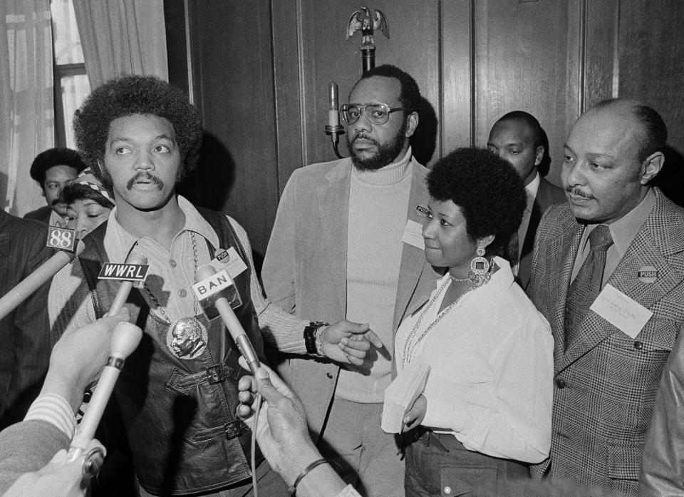 This March 26, 1972 file photo shows the Rev. Jesse Jackson speaking to reporters at the Operation PUSH Soul Picnic in New York as Tom Todd, vice president of PUSH, from second left, Aretha Franklin and Louis Stokes. Franklin died Thursday, Aug. 16, 2018 at her home in Detroit. She was 76. (AP Photo/Jim Wells, File)