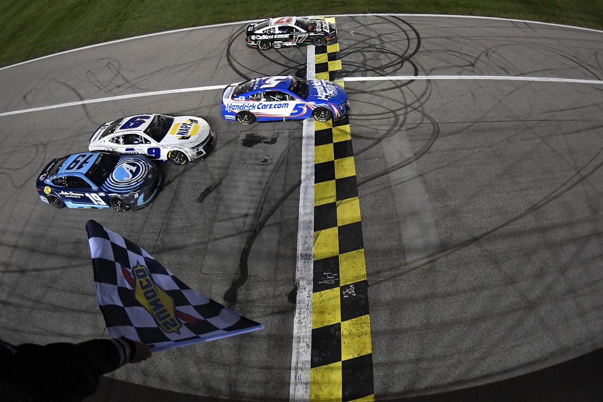 Kyle Larson (5) takes the checkered flag over Chris Buescher (17) to win the NASCAR Cup Series AdventHealth 400 at Kansas Speedway on Sunday in Kansas City. (Photo by Logan Riely/Getty Images)