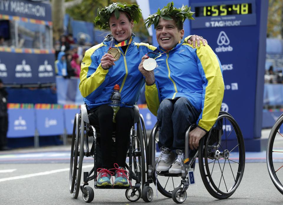 Tatyana McFadden of the USA (L) and Kurt Fearnley of Australia celebrate with their medals after winning the men's and women's wheelchair division of the 2014 New York City Marathon in Central Park in Manhattan, November 2, 2014. REUTERS/Mike Segar (UNITED STATES - Tags: SPORT ATHLETICS)
