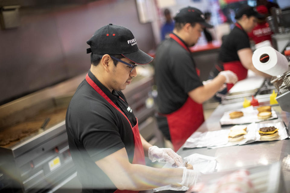 Workers prepare orders in Five Guys restaurant in Kensington, London, after the burger chain reopened eight of their sites, as the UK continues in lockdown to help curb the spread of the coronavirus.