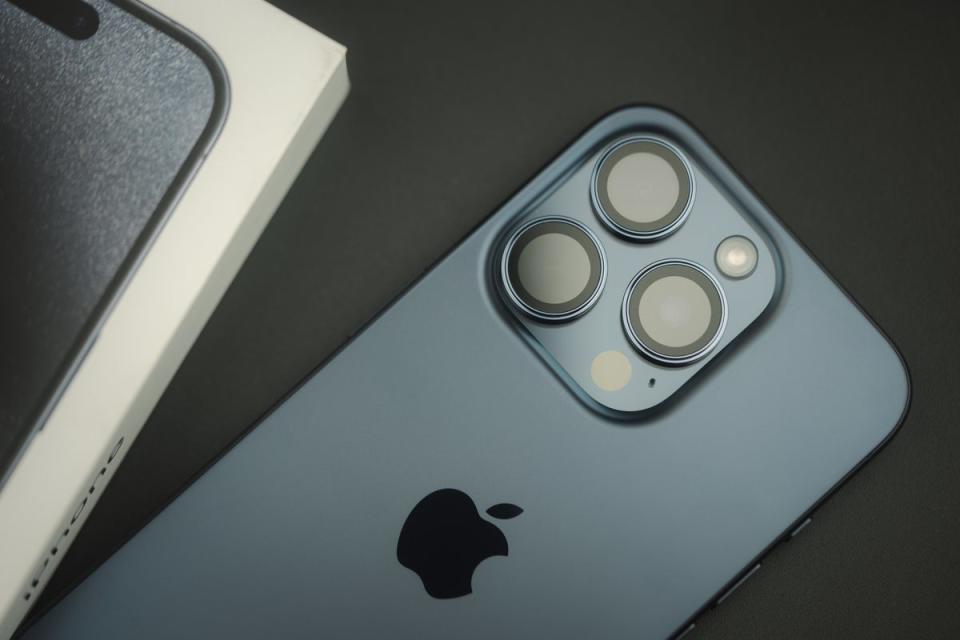 An iPhone 15 and its box sit on a black table. Only Apple’s iPhone 14 and newer generations support Messages via satellite. (Getty Images/iStock)