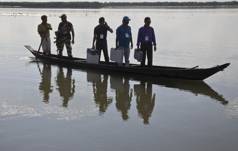 FILE - In this April 10, 2019 file photo, Indian election officers and paramilitary soldiers travel on a country boat with election material over the river Brahmaputra on the eve of first phase of general election in Majuli, Assam, India. The final phase of India’s marathon general election will be held on Sunday, May 19. The first of the election’s seven staggered phases was held on April 11. Vote counting is scheduled to start on May 23. India has 900 million eligible voters. (AP Photo/Anupam Nath, File)