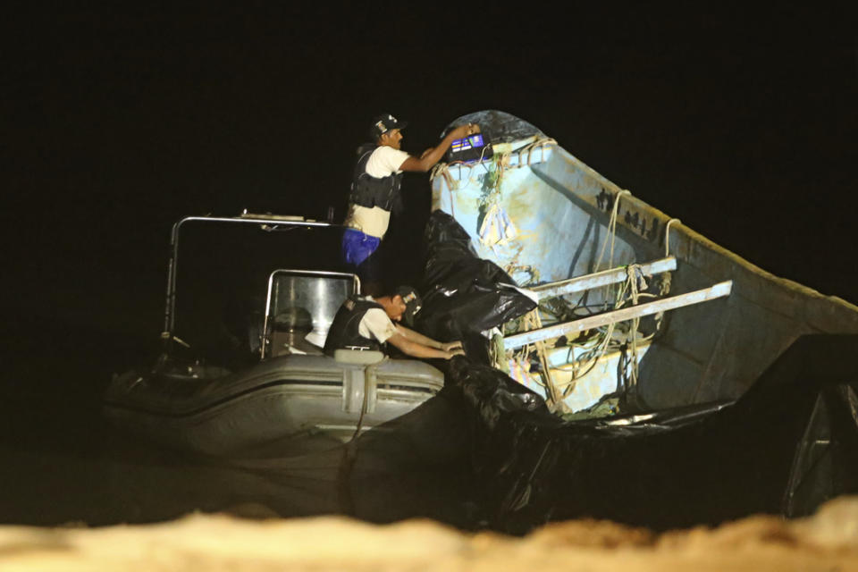 Police help move a boat that was carrying decomposing corpses to the Vila do Castelo port in Braganca, Brazil, early Monday, April 15, 2024. Security forces and forensics were dispatched to the area after fishermen reported on Saturday spotting a boat with decomposing corpses off the coast of Para state. (AP Photo/Raimundo Pacco)