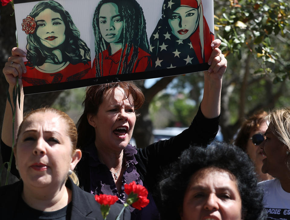 Laurie Woodward Garcia, center, joins other women on International Women's Day in front of&nbsp;a U.S. Department of Homeland Security and Immigration and Customs Enforcement office to ask for fair treatment and dignity for women who are called to the office.