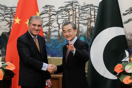Chinese Foreign Minister Wang Yi and Pakistani Foreign Minister Shah Mehmood Qureshi shake hands after a news conference at the Diaoyutai State Guesthouse in Beijing, China March 19, 2019. REUTERS/Thomas Peter