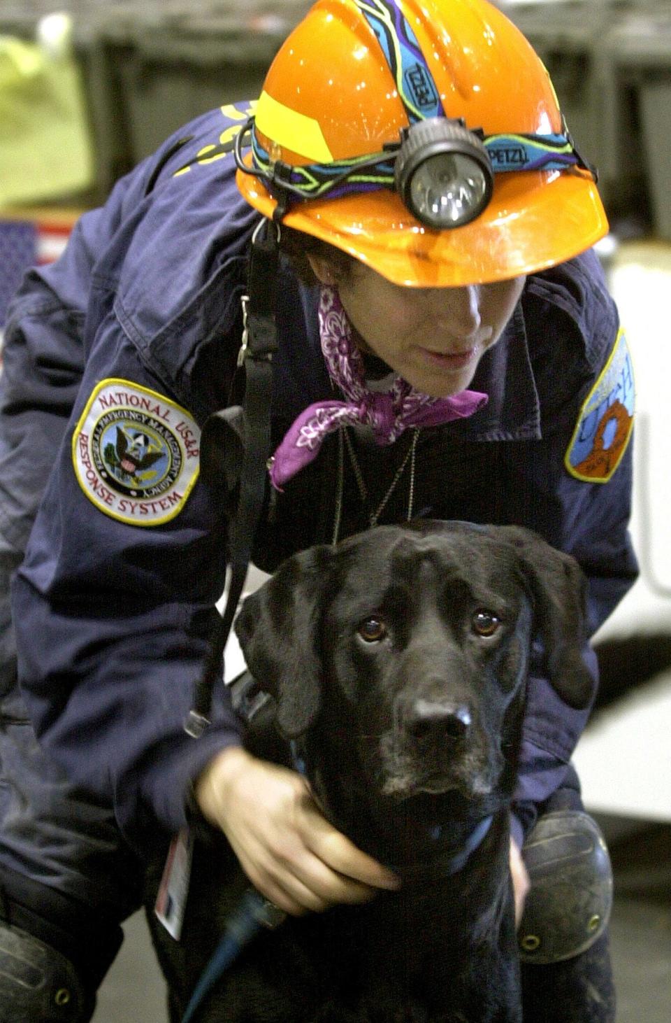 Mary Flood leashes her black Labrador retriever search and rescue dog, Jake, near the World Trade Center in New York in this Sept. 22, 2001 file photo.