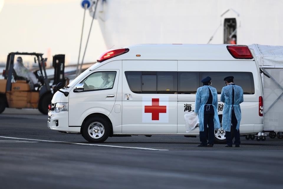 An ambulance carrying passengers drives away from the Diamond Princess cruise ship, with around 3,600 people quarantined onboard due to fears of the new coronavirus, at the Daikoku Pier Cruise Terminal in Yokohama port on February 10, 2020. - Around 60 more people on board the quarantined Diamond Princess cruise ship moored off Japan have been diagnosed with novel coronavirus, the country's national broadcaster said on February 10, raising the number of infected passengers and crew to around 130. (Photo by CHARLY TRIBALLEAU / AFP) (Photo by CHARLY TRIBALLEAU/AFP via Getty Images)