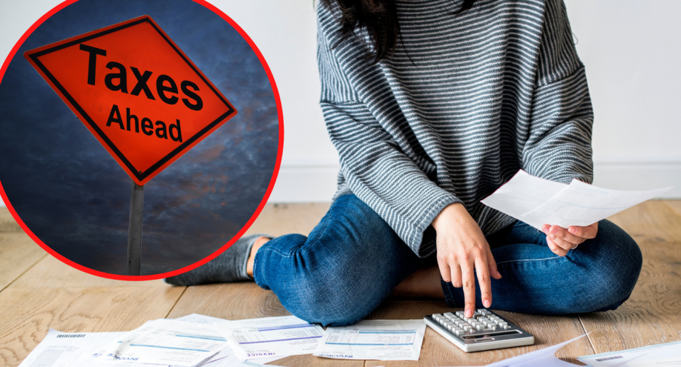 Woman holding papers and working on calculator with inset of road sign with taxes ahead written on it. 