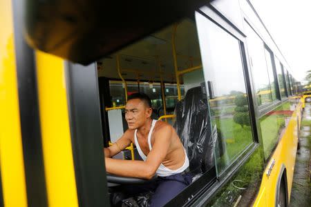 A driver sits in a new bus near Shwedagon Pagoda in Yangon, Myanmar July 21, 2017. Picture taken on July 21, 2017. REUTERS/Soe Zeya Tun