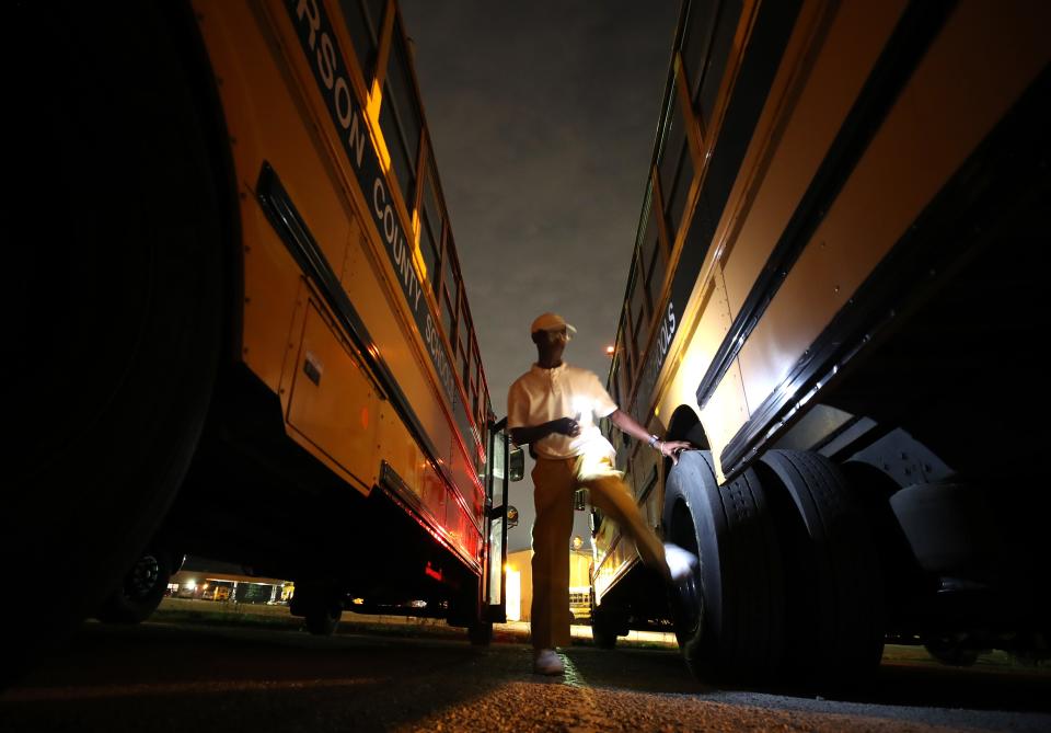 Dean Sutton, a Jefferson County Public Schools driver for more than 20 years, looks over his bus at the Nichols Compound prior to the start of his day on Monday, Aug. 21, 2023, in Louisville, Kentucky.