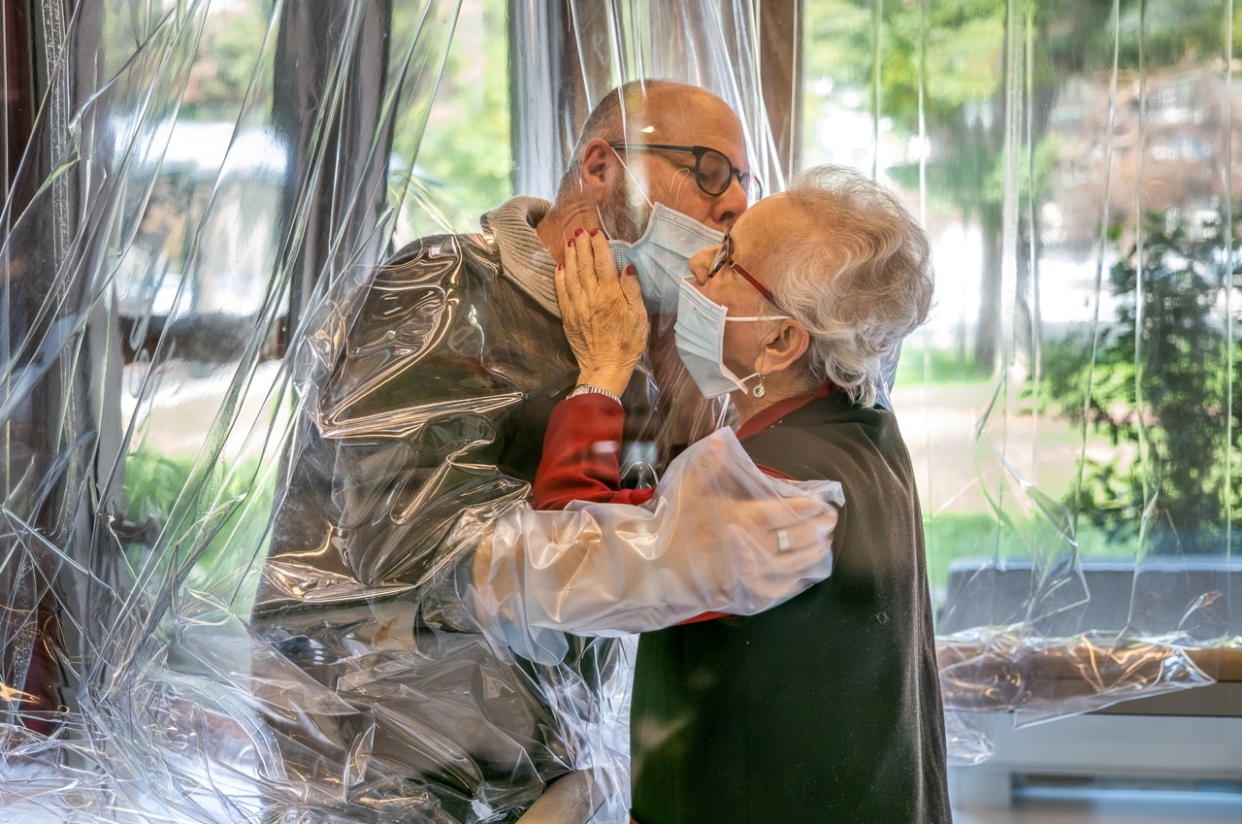 Resident kisses a relative through a plastic sheet installed in a special 'hug room' organised to keep both parties safe from novel coronavirus infection, at a care home in Castelfranco Veneto, Italy, in this handout photo released on November 11, 2020. Centro residenziale per anziani Domenico Sartor/Handout via REUTERS ATTENTION EDITORS THIS IMAGE HAS BEEN SUPPLIED BY A THIRD PARTY.     TPX IMAGES OF THE DAY