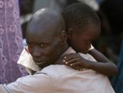 An internally displaced man holds his son inside a United Nations Missions in Sudan (UNMIS) compound in Juba December 19, 2013. South Sudanese government troops battled to regain control of a flashpoint town and sent forces to quell fighting in a vital oil producing area on Thursday, the fifth day of a conflict that that has deepended ethnic divisions in the two-year-old nation. REUTERS/Goran Tomasevic (SOUTH SUDAN - Tags: CIVIL UNREST POLITICS TPX IMAGES OF THE DAY)