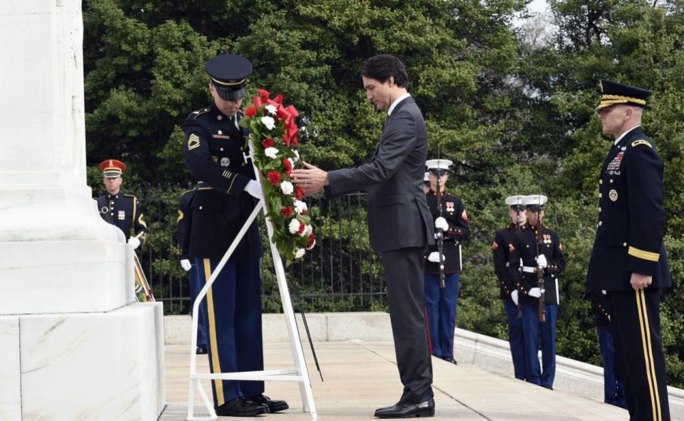 Prime Minister Justin Trudeau, center, accompanied by Maj. Gen. Bradley A. Becker, Commanding General , U.S Army Military District of Washington, right, lays a wreath at the Tomb of the Unknowns at Arlington National Cemetery in Arlington, Va., Friday, March 11, 2016. (AP Photo/Susan Walsh)