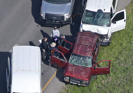 Law enforcement personnel investigate the scene where the Texas bombing suspect blew himself up on the side of a highway north of Austin in Round Rock, Texas, U.S., March 21, 2018. REUTERS/Loren Elliott