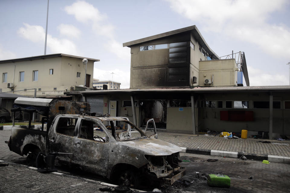 Burnt vehicles are seen near the Lekki toll gate, in Lagos Friday, Oct. 23, 2020. Resentment lingered with the smell of charred tires Friday as Nigeria's streets were relatively calm after days of protests over police abuses, while authorities gave little acknowledgement to reports of the military killing at least 12 peaceful demonstrators earlier this week. (AP Photo/Sunday Alamba)