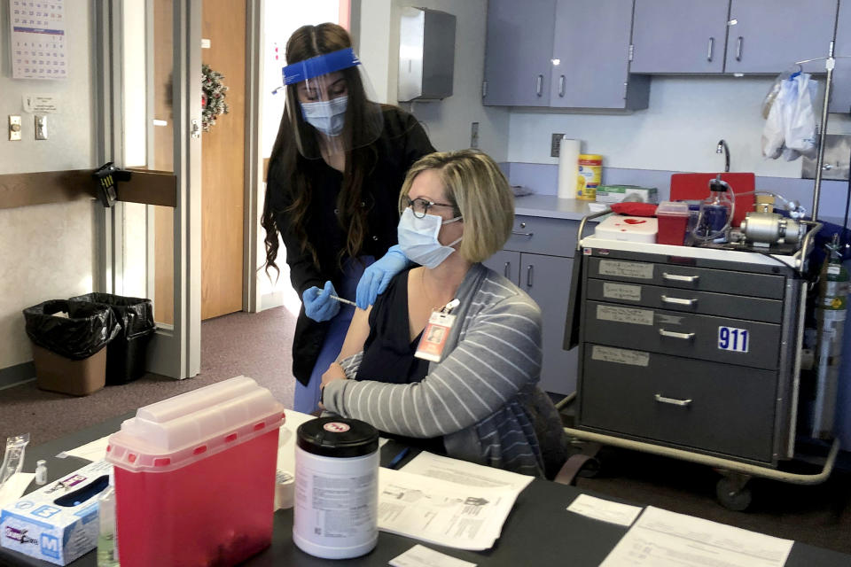 A Cheyenne-Laramie County Health Department nurse administers Wyoming's first shot of the Pfizer-BioNTech Covid-19 vaccine to Terry Thayn, who is also a nurse for the department, on Dec. 15, 2020, in Cheyenne, Wyo. (Mead Gruver / AP file)