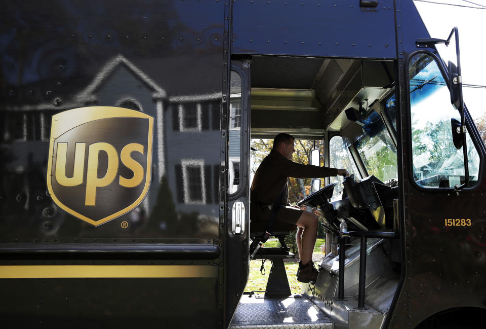 In this Monday, Oct. 22, 2012, photo, a UPS driver makes a delivery in North Andover, Mass. UPS said Tuesday, Oct. 23, 2012, its third-quarter earnings sank on a huge penalty to withdraw from a pension plan. Without that charge, net income fell slightly but matched expectations on Wall Street. The world's largest package delivery company is also narrowing its earnings forecast for the full year. (AP Photo/Elise Amendola)