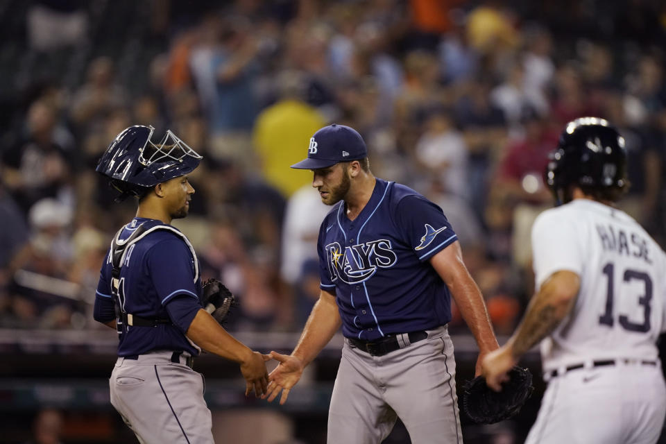 Tampa Bay Rays relief pitcher Colin Poche greets catcher Francisco Mejia after the ninth inning of a baseball game against the Detroit Tigers, Friday, Aug. 5, 2022, in Detroit. (AP Photo/Carlos Osorio)