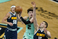 Charlotte Hornets guard LaMelo Ball shoots over Denver Nuggets center Nikola Jokic during the second half of an NBA basketball game on Tuesday, May 11, 2021, in Charlotte, N.C. (AP Photo/Chris Carlson)