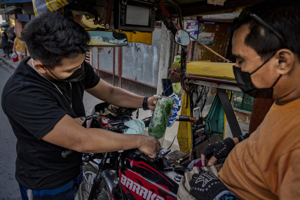 MANILA, PHILIPPINES - MARCH 07: A man loads a tricycle with gasoline from a used liquor bottle sold on the side of a road, a day before a huge price increase on petroleum products is implemented, on March 07, 2022 in Quezon City, Metro Manila, Philippines. Shares in Asian markets declined on Monday amid fears of an inflation shock in the world economy already reeling from pandemic-era snarls as the ongoing Russia-Ukraine war continues to send oil prices soaring. (Photo by Ezra Acayan/Getty Images)