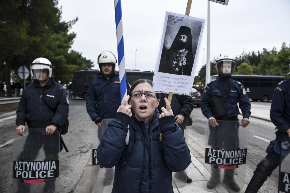 A woman, holding a photograph of a Greek Orthodox Metropolitan, chants slogans against Greece's name deal with neighboring Macedonia, near Evzonoi border crossing in Greece, Sunday, Sept. 30, 2018. Macedonians were deciding on their country's future Sunday, voting whether to accept a landmark deal ending a decades-long dispute with neighboring Greece by changing their country's name to North Macedonia. (AP Photo/Giannis Papanikos)