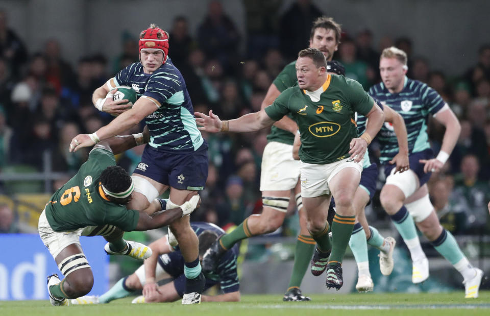 FILE - Ireland's Josh van der Flier, middle, is tackled by South Africa's captain Siya Kolisi, left, during the rugby union international match between Ireland and South Africa at the Aviva Stadium in Dublin, Ireland, Saturday, Nov. 5, 2022. (AP Photo/Peter Morrison, File)