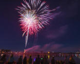 FILE - In this July 4, 2017, file photo, people watch the Fourth of July fireworks display from the dock as the fireworks are launched over Prospect Lake at Memorial Park in Colorado Springs, Colo. For many Americans, the Fourth of July won't be about big festivities but setting off fireworks themselves. Hundreds of cities have canceled shows Saturday, July 4, 2020, because of the coronavirus pandemic, and sales of consumer fireworks are booming. (Dougal Brownlie/The Gazette via AP, File)