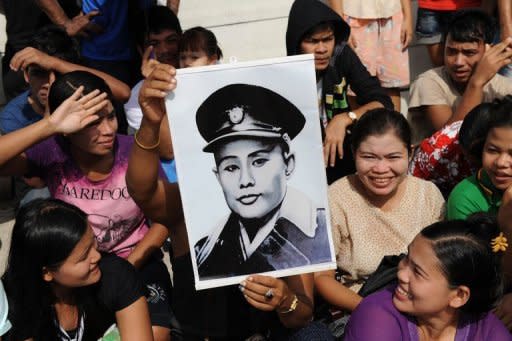 A supporter of Myanmar opposition leader Aung San Suu Kyi holds a portrait of her father and independence hero General Aung San ahead of her arrival in Samut Sakhon on the outskirts of Bangkok on May 31. Suu Kyi is on her first trip abroad in 24 years