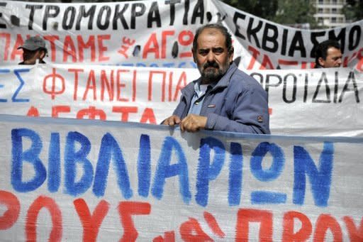 Greek construction workers stand behind banners in front of the labour ministry in Athens on April 4 during their protest against the austerity measures and the unemployment in their sector. The eurozone debt crisis delivered more bad news on Monday with data showing record high unemployment of 11.1 percent and a manufacturing outlook at its lowest levels for three years