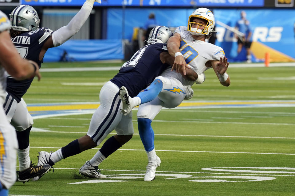 Los Angeles Chargers quarterback Justin Herbert is hit by Dallas Cowboys linebacker Micah Parsons as he throws during the second half of an NFL football game Sunday, Sept. 19, 2021, in Inglewood, Calif. (AP Photo/Gregory Bull)