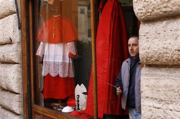 A man walks past a shop window displaying cardinals' dresses in downtown Rome February 16, 2012. Pope Benedict will create 22 new red-hatted "princes of the church" in a consistory ceremony at the Vatican.