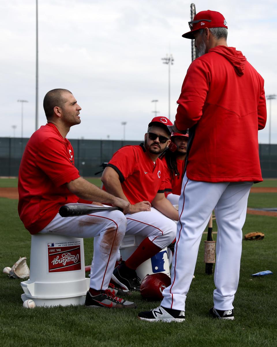 Cincinnati Reds first baseman Joey Votto (19), third baseman Eugenio Suarez (7) and shortstop Freddy Galvis (3) talk with Cincinnati Reds hitting coach Alan Zinter (59) during live batting practice, Sunday, Feb. 23, 2020, at the baseball team's spring training facility in Goodyear, Ariz. 