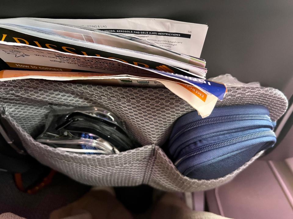 A view of the seatback pocket with my medicine and cables inside.