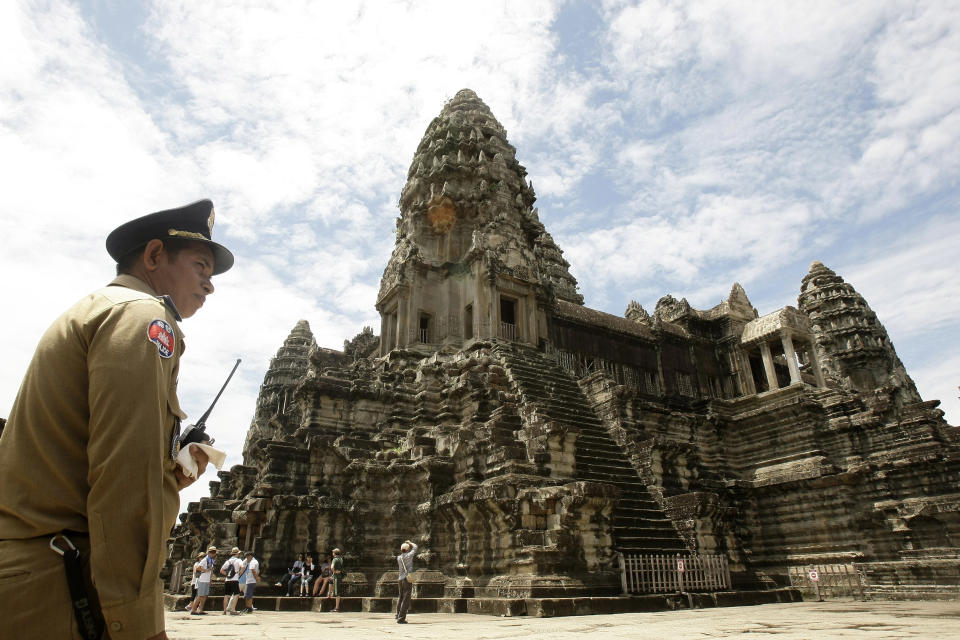 FILE - In this June 28, 2012 file photo, a police officer stands guard at Cambodia's famed Angkor Wat temple complex in Siem Reap province, some 230 kilometers (143 miles) northwest Phnom Penh, Cambodia. The spectacular temples of Cambodia’s historic Angkor civilization have been incorporated into Google’s Street View. The Internet giant said in a statement Thursday, April 3, 2014 that Street View now includes more than 90,000 photographic panoramas of the area, and allows viewers to zoom in to study carvings and other artistic and archaeological details. (AP Photo/Heng Sinith, File)