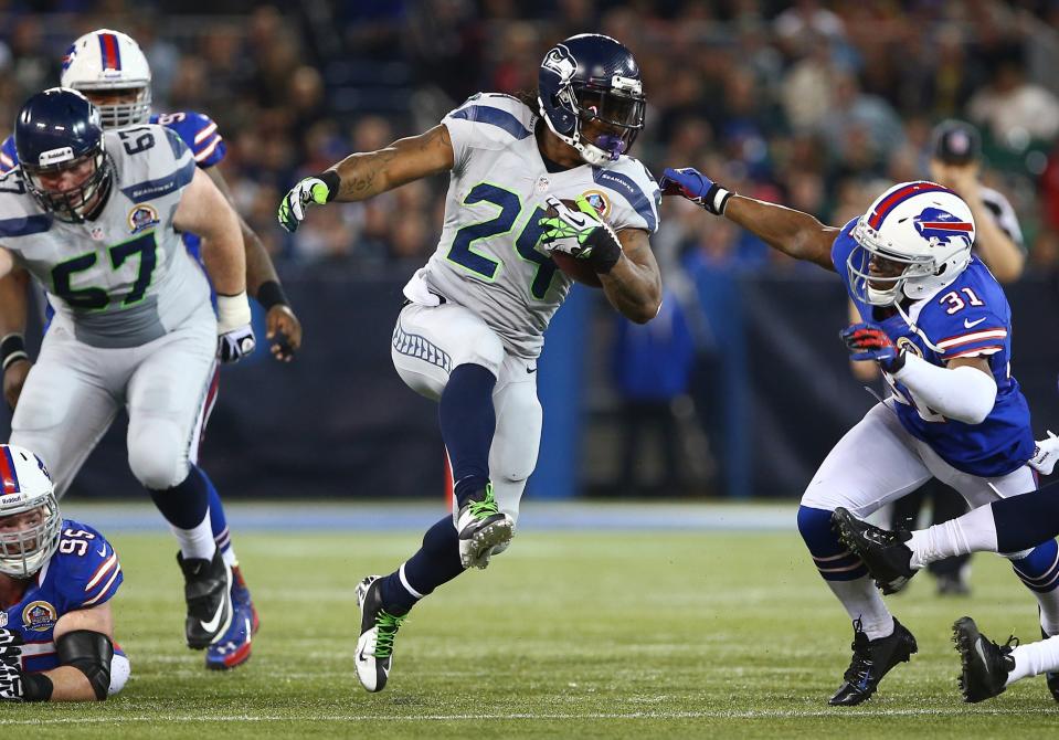 TORONTO, ON - DECEMBER 16: Marshawn Lynch #24 of the Seattle Seahawks carries the ball during an NFL game as Jairus Byrd #31 of the Buffalo Bills attempts to tackle him at Rogers Centre on December 16, 2012 in Toronto, Ontario, Canada. (Photo by Tom Szczerbowski/Getty Images)