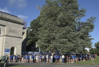 People gather near the entrance to Memorial Stadium, home of the Indiana State Sycamores NCAA college football team, during a vigil for victims of a car crash in Terre Haute, Ind., Aug. 21, 2022. (Joseph C. Garza/The Tribune-Star via AP)