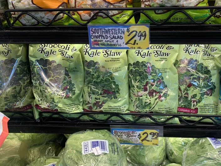 bags of Trader Joe's broccoli-kale slaw in produce section
