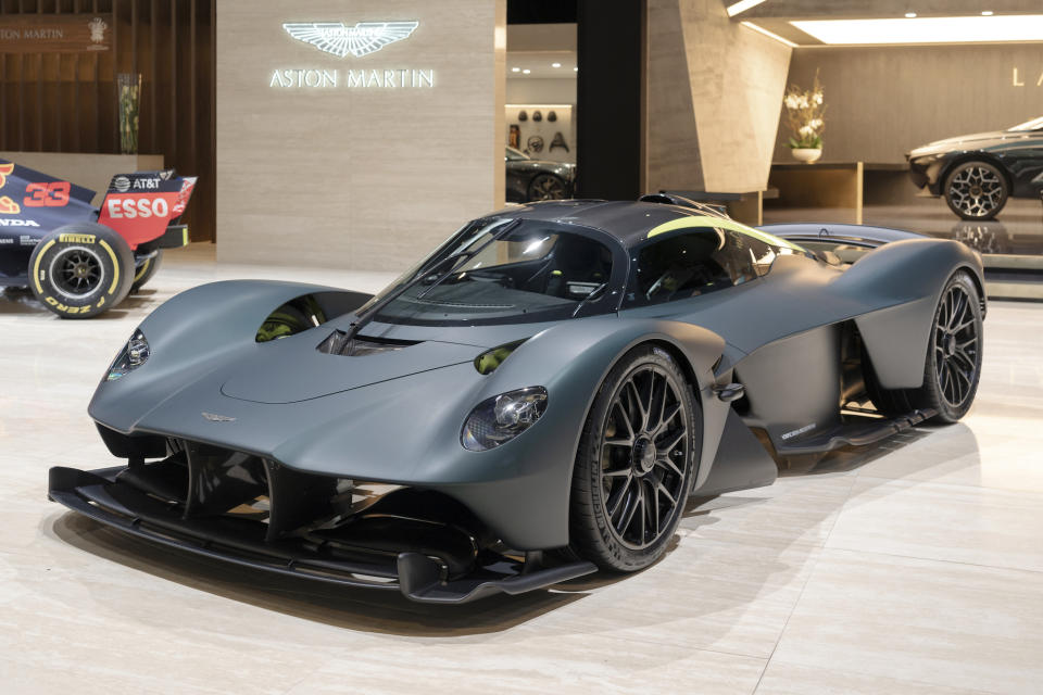 A gray Aston Martin Valkrye, a low-slung mid-engined sports car, shown on Aston Martin's show stand at the 2019 Geneva Motor Show.